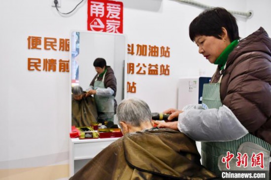 胡玉斐(右一)在當?shù)毓嬲久β?。羅夢圓 攝